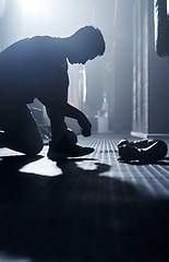 Image showing Work hard and trust the process. a sporty young man tying his laces before boxing in a gym.