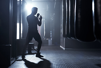 Image showing A warrior never worries about his fear. a sporty young man kickboxing in a gym.