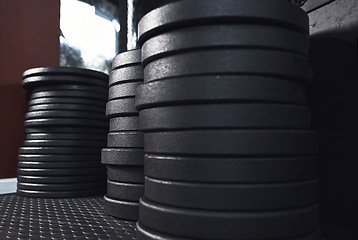 Image showing It never gets easier, you just get stronger. Still life shot of weight plates in a gym.