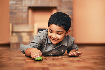 Image showing Watch how fast my car can go. an adorable little boy playing with a toy car at home.