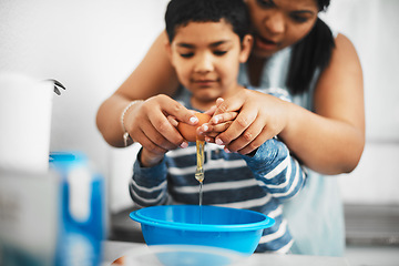 Image showing We have to crack this carefully. a mother and her little son cracking an egg together while baking at home.