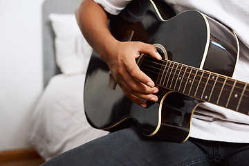 Image showing It requires patience, perseverance and dedication. a young man playing the guitar while sitting at home.