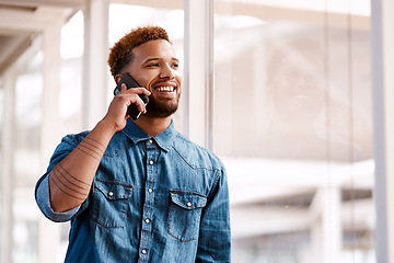 Image showing Business relationships are the key to success. a handsome young male designer making a phonecall while standing at at a window in his office.