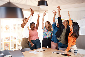 Image showing Celebrating greatness. a group of young designers raising their hands in celebration while standing in the boardroom of their office.