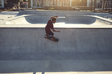 Image showing Speed and balance is a powerful combo. High angle shot of a young man doing tricks on his skateboard at a skate park.