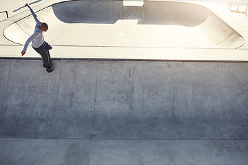 Image showing Life is all about taking risks. High angle shot of a young man doing tricks on his skateboard at a skate park.