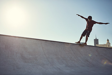 Image showing Spread your wings and fly. Full length shot of a young man doing tricks on his skateboard at a skate park.