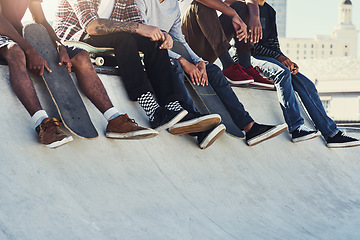 Image showing Kicking back at the skatepark. a group of unrecognizable skaters sitting together on a ramp at a skatepark.