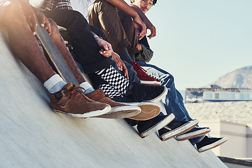 Image showing We have the whole world at our feet. a group of unrecognizable skaters sitting together on a ramp at a skatepark.