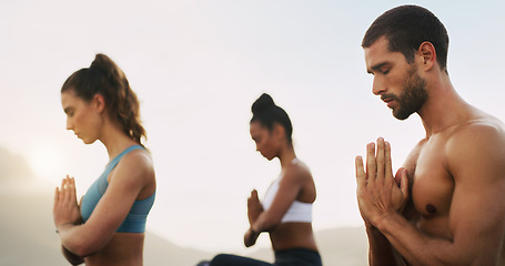 Image showing We didnt choose the zen life, it chose us. a group of young people sitting and meditating together while on the beach during an overcast day.