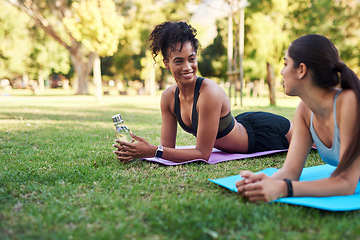 Image showing Ready for some yoga. two attractive young women stretching next to each other in the park during the day.