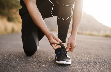 Image showing Lacing up to run in the direction of his goals. Closeup shot of an unrecognizable man tying his shoelaces while exercising outdoors.