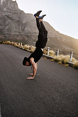 Image showing Let me show you how fit and flexible I am. a sporty young man doing a handstand while exercising outdoors.