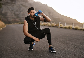 Image showing Hydration is key. a sporty young man drinking water while exercising outdoors.