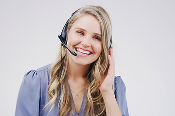 Image showing Happy call centre agents make happy customers. Studio shot of an attractive young female customer service representative wearing a headset against a grey background.