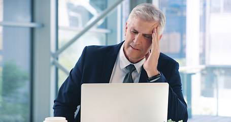 Image showing I cant think straight with this headache. a mature businessman looking stressed out while working in an office.