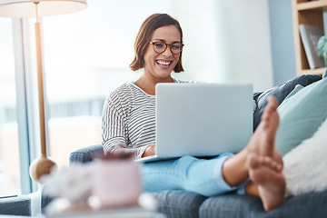 Image showing My blog is getting more and more followers. Full length shot of a happy young woman using a laptop while relaxing in her living room.