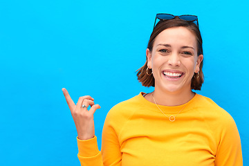 Image showing Ive got a new exciting idea up here. Cropped portrait of a happy young woman pointing up against a blue background.