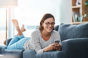 Image showing Somebodys texting her crush. Full length shot of a happy young woman using her smartphone on the sofa at home.