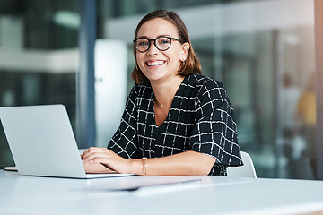 Image showing The best job comes with lots of smiles. Cropped portrait of a happy young businesswoman working on a laptop in an office.