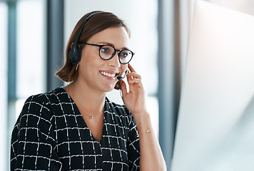 Image showing Making happy business calls. a happy young call centre agent working in an office.