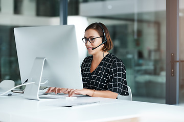 Image showing Shell work swiftly to resolve your issues. a happy young call centre agent working on a computer in an office.