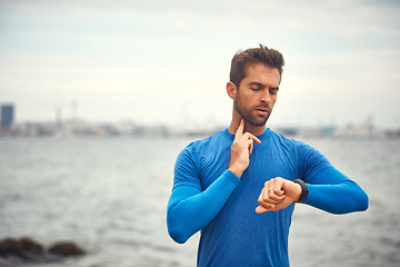 Image showing Exercise makes the heart beat faster. a sporty middle-aged man checking his pulse while out exercising.