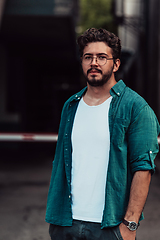 Image showing A portrait of a modern man, exuding confidence and style, against an outdoor backdrop, showcasing his charisma and fashionable demeanor.