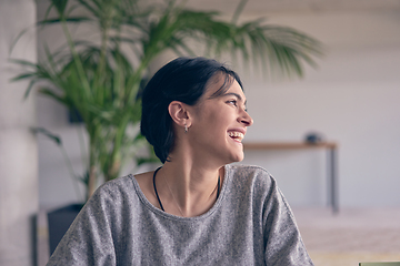 Image showing In a modern office, a young smile businesswoman with glasses confidently explains and presents various business ideas to her colleagues, showcasing her professionalism and expertise.