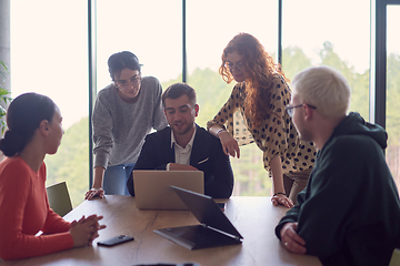 Image showing A diverse group of business professionals gathered at a modern office for a productive and inclusive meeting