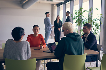 Image showing A diverse group of business professionals gathered at a modern office for a productive and inclusive meeting