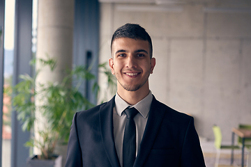 Image showing A confident businessman with a briefcase strides through a modern office, exuding charisma and determination, symbolizing success and professional excellence.