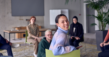 Image showing A young female entrepreneur is attentively listening to a presentation by her colleagues, reflecting the spirit of creativity, collaboration, problem-solving, entrepreneurship, and empowerment.