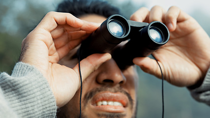 Image showing Face, hiking and man with binocular in nature for sightseeing, explore or trekking a mountain environment. Travel, adventure and view with a young male hiker closeup outdoor in the woods or forest