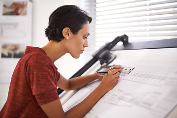 Image showing Paying attention to the finer details. an attractive young architect working in her office.