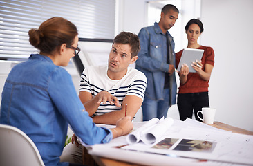 Image showing Perfecting their designs through thorough examination. a group of young designers working together in an office.