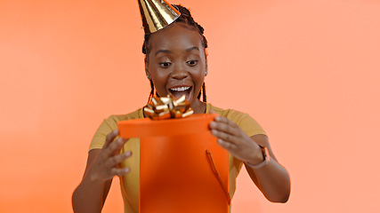 Image showing Birthday, surprise and black woman with present, box or gift on studio peach background or unboxing. Wow, congratulations or excited for giveaway, package or celebration of product on offer at party