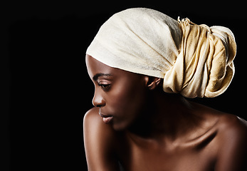 Image showing Simplicity is the keynote of elegance. Studio shot of a beautiful woman wearing a headscarf against a black background.