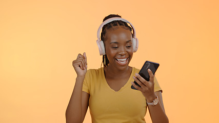 Image showing Woman, music and headset on smartphone to dance, stream podcast or excited by orange background. Happy black person, technology and listen to playlist with online audio, radio and studio mockup