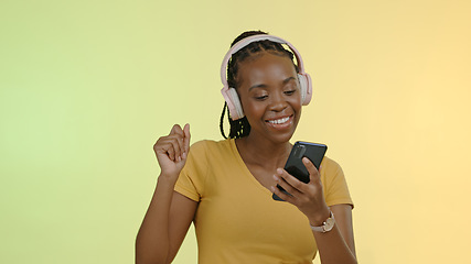 Image showing Face, woman and headphones on phone to dance, stream music and podcast by yellow background. Happy black person, excited and technology and listen to playlist or audio, radio and studio mockup