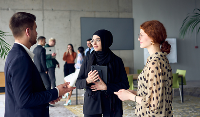 Image showing A group of young business entrepreneurs engages in a lively discussion within the office, exemplifying the spirit of teamwork, innovation, and ambition in pursuit of success.