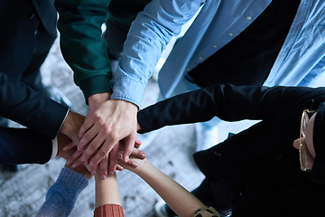 Image showing A top view photo of group of businessmen holding hands together to symbolize unity and strength