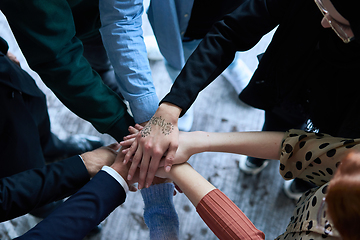 Image showing A top view photo of group of businessmen holding hands together to symbolize unity and strength