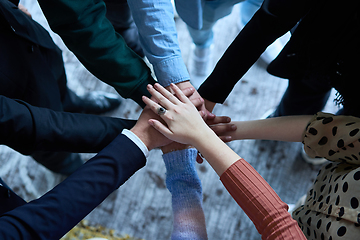 Image showing A top view photo of group of businessmen holding hands together to symbolize unity and strength