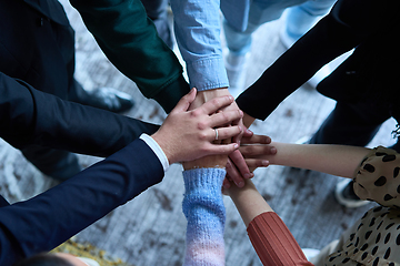 Image showing A top view photo of group of businessmen holding hands together to symbolize unity and strength