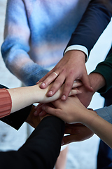 Image showing A top view photo of group of businessmen holding hands together to symbolize unity and strength