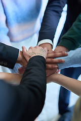 Image showing A top view photo of group of businessmen holding hands together to symbolize unity and strength