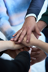 Image showing A top view photo of group of businessmen holding hands together to symbolize unity and strength