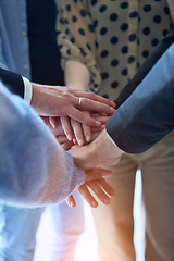 Image showing A top view photo of group of businessmen holding hands together to symbolize unity and strength