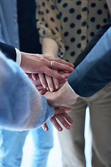 Image showing A top view photo of group of businessmen holding hands together to symbolize unity and strength